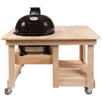 Primo Oval Junior 200 Ceramic Kamado Grill with stainless steel grates on cypress wood table