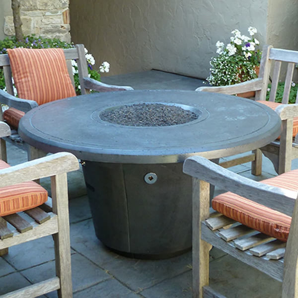 Cosmopolitan 48 inch round concrete fire pit table by American Fyre Designs in outdoor backyard setting