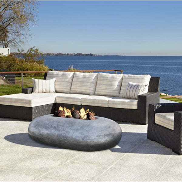Pebble 56 inch oval concrete fire pit table by Prism Hardscapes with lava rock burning display
