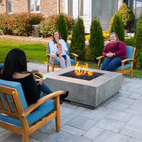 48-inch square Tavola III gas fire table by Prism Hardscapes with concrete construction and lava rock burning display