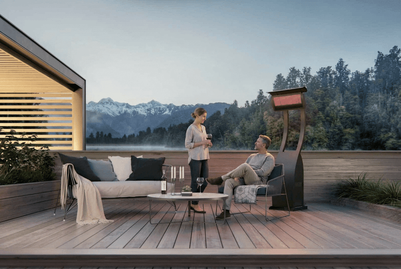 Bromic Tungsten Freestanding gas heater beside a deck seating area with mountain views. Manufacturer installation inspiration; accessories shown sold separately.