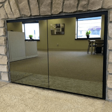 Odyssey Masonry and Prefab fireplace glass doors with solar reflective glass and flat black powder coat frame