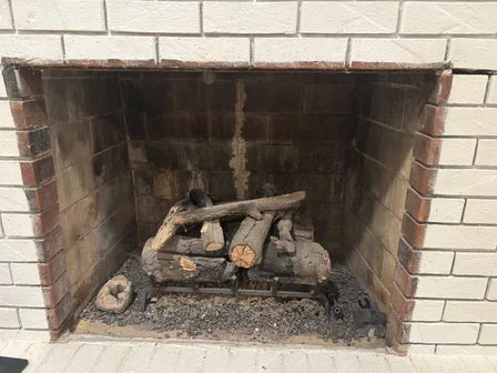 Masonry fireplace opening: firebrick inside, brick right up to the edge, a thin steel lintel bar across the top, no metal box.